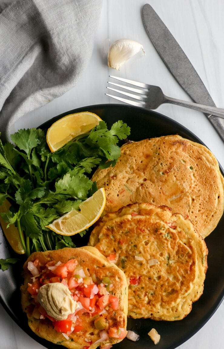 Chickpea pancakes topped with salsa, lemon slices and cilantro.