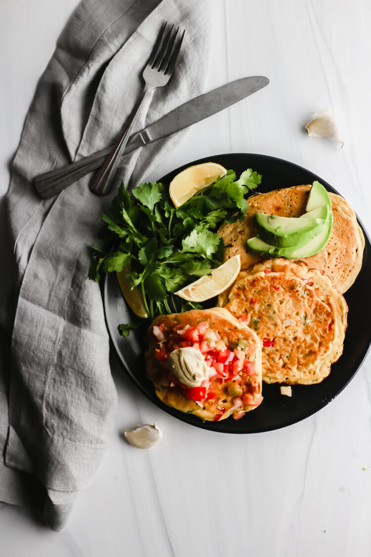 Easy savory vegetarian breakfast recipes &mdash; chickpea pancakes with herbs on a white plate