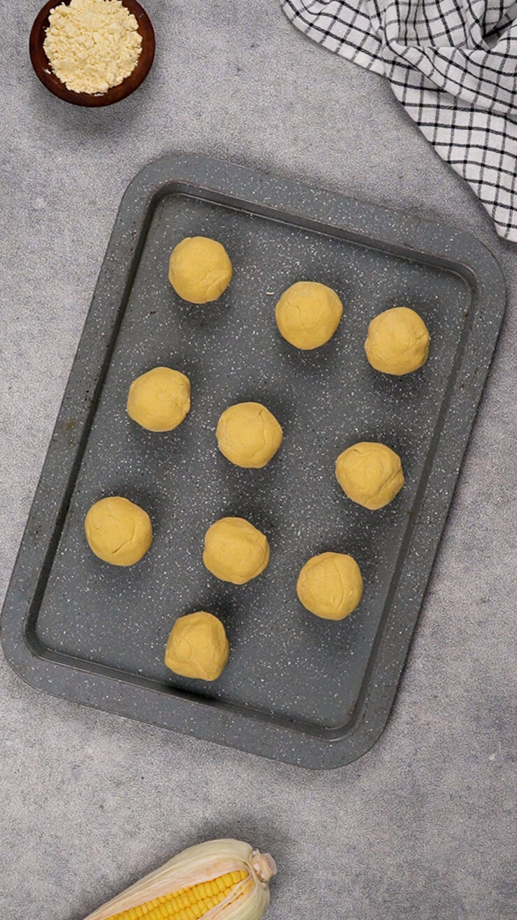 Balls of dough sit on a baking tray for a masa harina tortilla recipe.