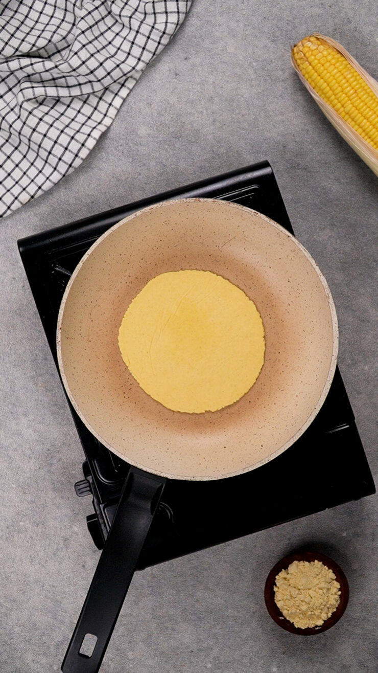 A masa harina tortilla sits inside a pan.