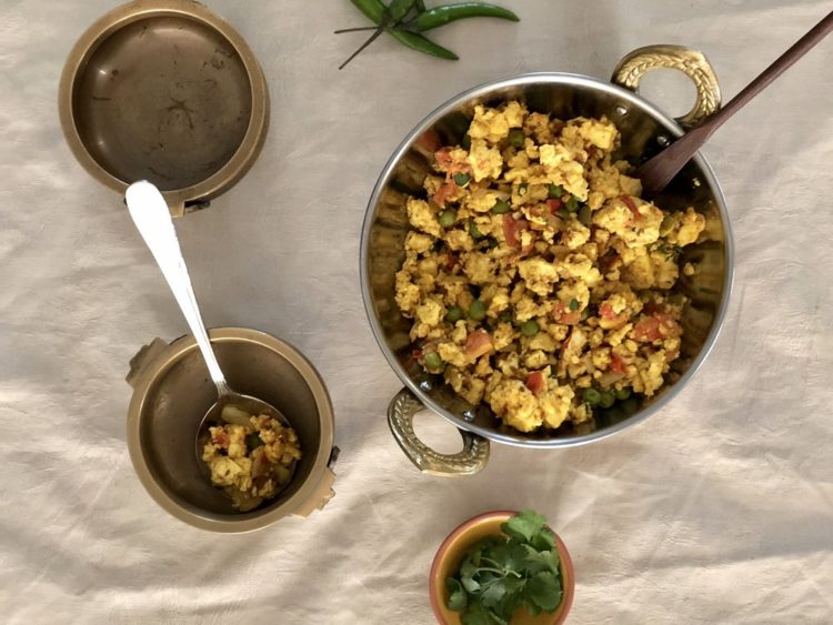 Pan full of a cottage cheese paneer scramble, studded with peas and tomatoes