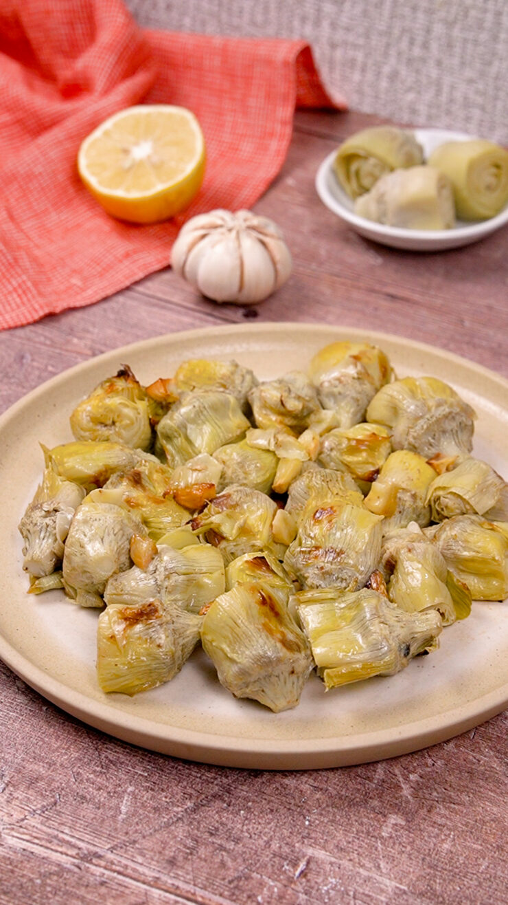 Plated baked artichoke hearts in olive oil and garlic.