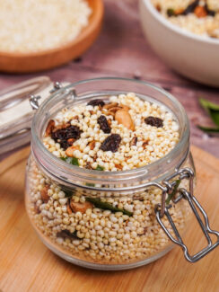 Jar full of puffed millet, peanuts, curry leaves, mustard seeds, sunflower seeds, and raisins.