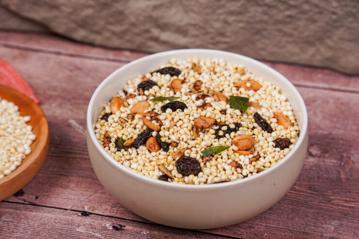 White bowl filled with namkeen, a mixture of puffed millet, raisins, peanuts, sunflower seeds, and spices.