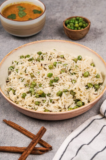Pea pulao with basmati rice and green peas resting in a bowl.
