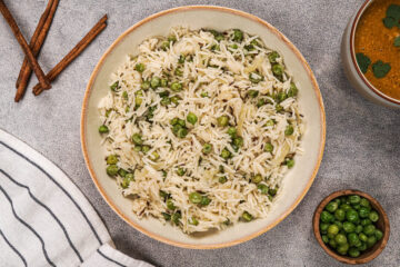 Pea pulao recipe resting in a bowl in the kitchen.