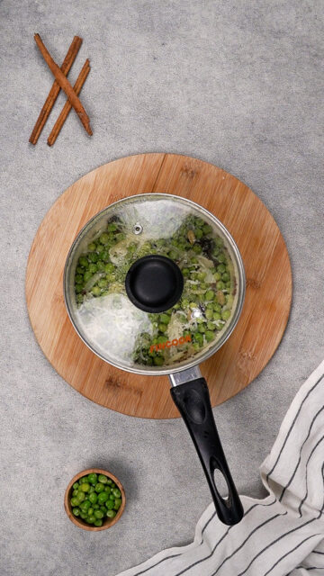 A pea pulao recipe sits in a pan with the lid on.