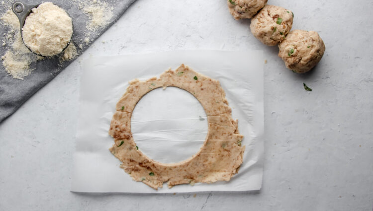 Keto flatbread recipe dough, cut using a cookie cutter and arranged into small balls ready to be rolled.
