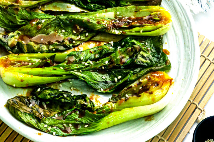 Miso Glazed Bok Choy on a White Plate With Sesame Seeds on Top