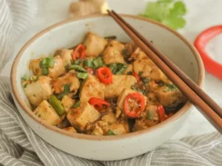 Black Pepper Tofu in a Bowl With Chopsticks on the Side
