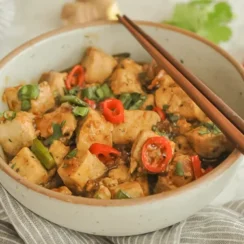 Black Pepper Tofu in a Bowl With Chopsticks on the Side