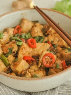Black Pepper Tofu in a Bowl With Chopsticks on the Side