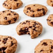 Chocolate chip cookies on a white counter. This article provides a recipe for dairy-free chocolate chip cookies.
