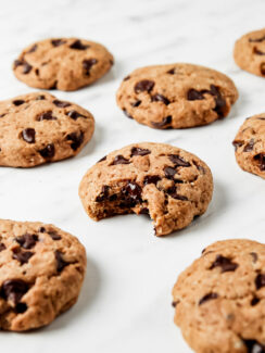 Chocolate chip cookies on a white counter. This article provides a recipe for dairy-free chocolate chip cookies.
