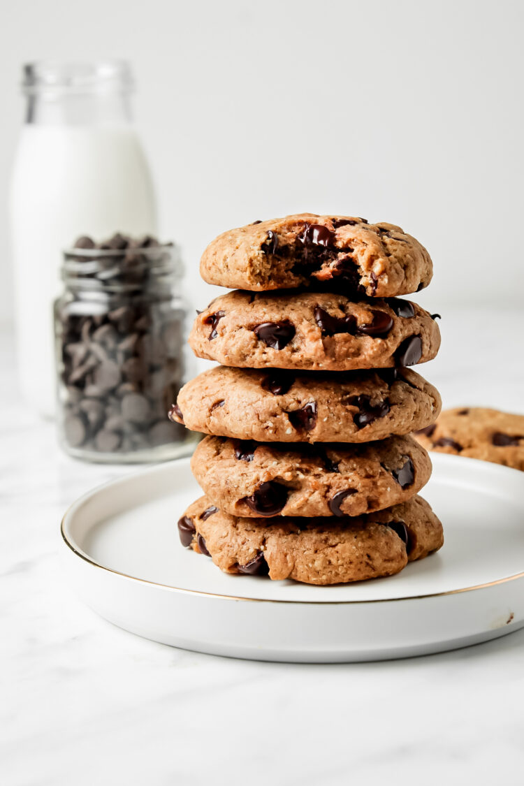 Stack of 5 vegan chocolate chip cookies on a white plate.