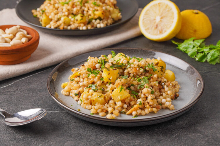 Two plates full of sabudana khichdi and lemon halves in the background