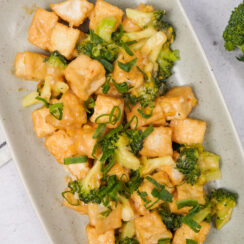 Broccoli stir fry with crispy tofu and green onions in a creamy savory sauce, featured in a guide to the best veggie stir fry recipes.