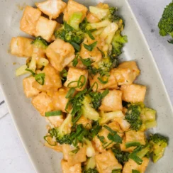 Broccoli stir fry with crispy tofu and green onions in a creamy savory sauce, featured in a guide to the best veggie stir fry recipes.