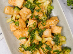 Broccoli stir fry with crispy tofu and green onions in a creamy savory sauce, featured in a guide to the best veggie stir fry recipes.