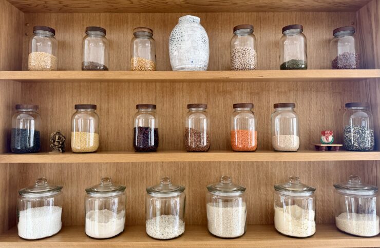 Wooden shelves full of jars containing different types of dried lentils.