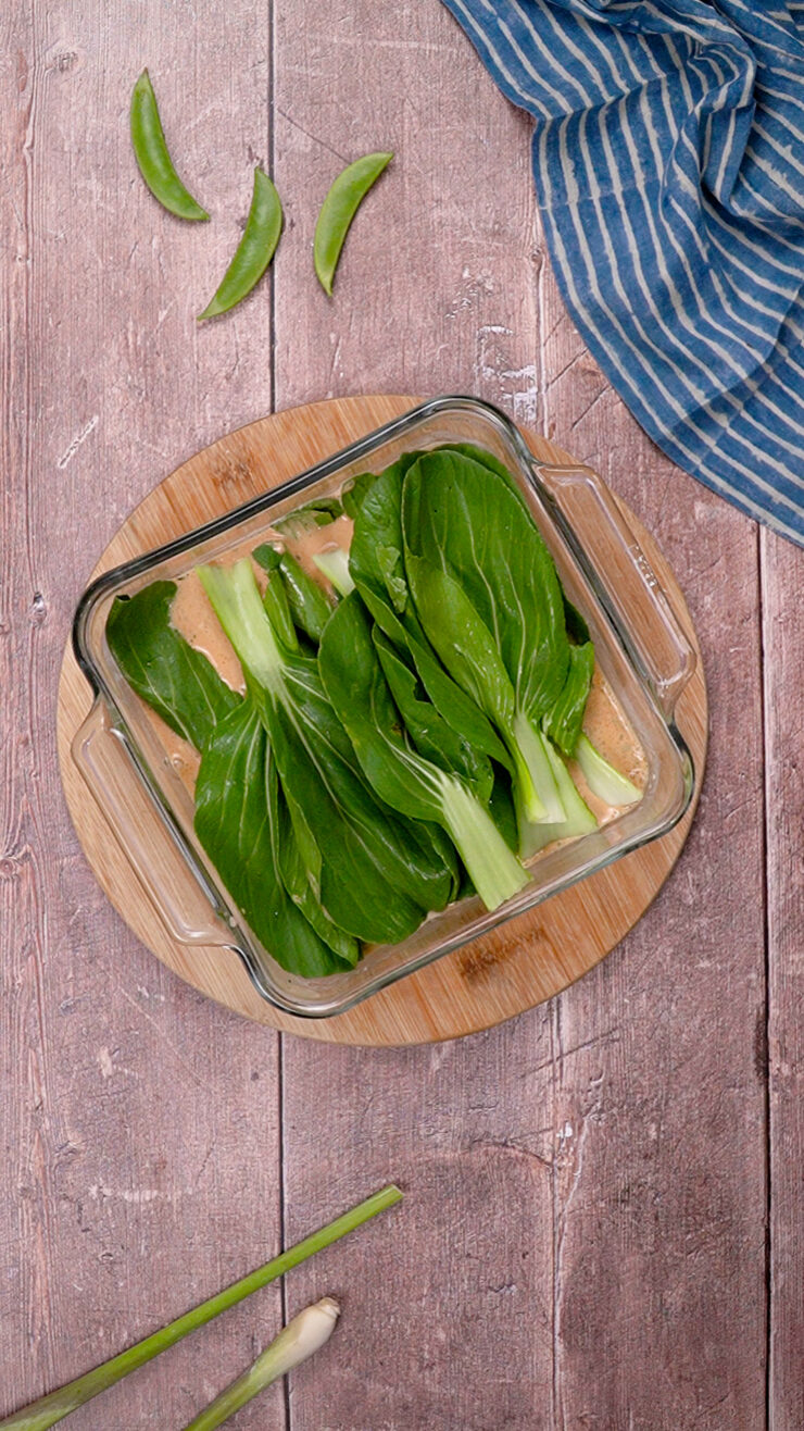 Bok choy leaves placed in a glass baking dish.
